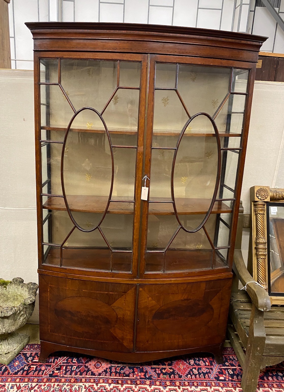 An early 20th century George III style mahogany bow front display cabinet, width 124cm, depth 40cm, height 197cm